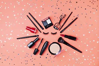 Cosmetic for woman makeup and beauty products decorated star confetti on coral table top view. Flat lay style