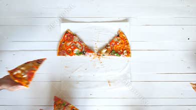 Top view male and female hands taking slices of pizza with cheese, tomatoes and ham from food delivery. Group of hungry