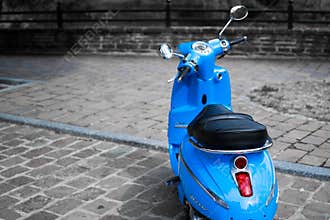Desatured picture of blue classic scooter or vespa Peugeot Django parked in the street