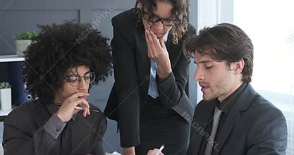 Business team using digital tablet and writing notes