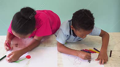 African American kids learning how to draw with crayon on table