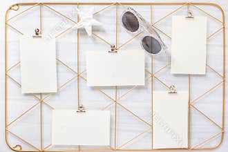 Top view set of note pad clip frame and star fish stone with sunglasses on white wood table.summer vacation background