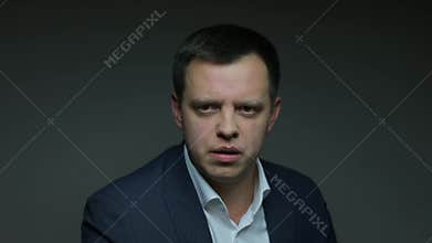 Male announcer on dark background says