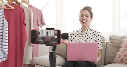 Teenage vlogger using laptop and recording new video at her boutique