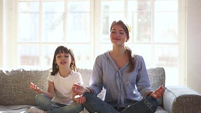 Happy healthy kid daughter and mother having fun doing yoga