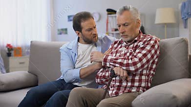 Middle-aged male comforting retiree father, suffering loss of wife, depression