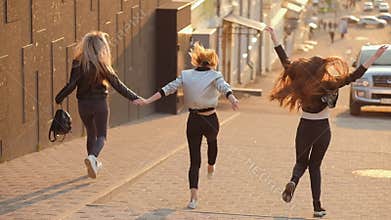 Joyful female friends happy girls running street
