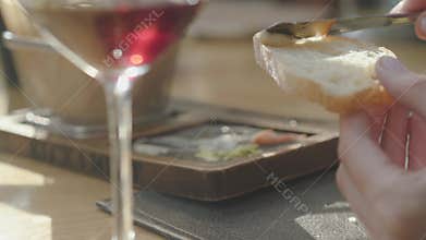 Female hand smearing on bread delicious cheeses and sauces from beautifully served plate in restaurant. Close up
