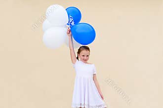 Happy little girl with blue and white balloons.