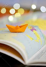 Paper boat on a atlas book