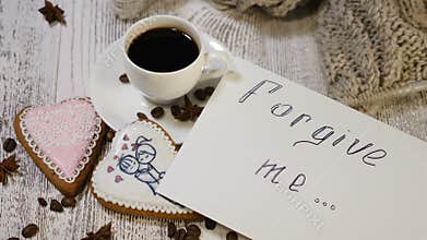 Begging for forgiveness. Love relations. Top view of cup of coffee and ginger biscuits heart shaped on wooden background