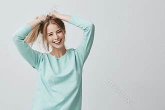 Human face expressions and emotions. Positive young beautiful female with dyed blonde straight hair in ponytail dressed