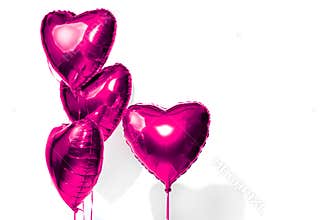 Valentine`s Day. Air balloons. Bunch of purple heart shaped helium balloons isolated on white