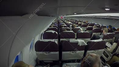 Economy class passengers sitting inside plane cabin. Air transport services