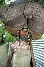 Portrait of Bangladeshi fisherman lugging fishnet