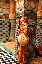 A beautiful Russian girl in a bright long dress in the palace of Fes takes pictures