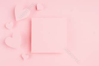 Valentines day background with blank page and paper hearts on gentle pink color background.