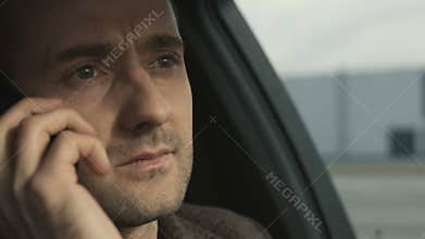 Business man speak by phone sitting in car closeup