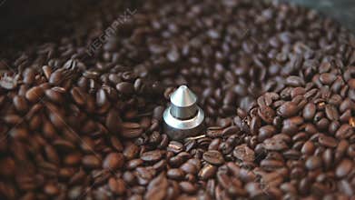 The Mixer of The Device of the roasting aromatic Coffee beans close up in slowmotion. Stages of coffee preparation and