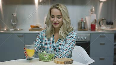 Woman drinking juice and eating salad