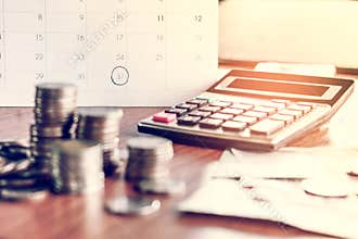 Debt collection and tax season concept with deadline calendar remind note,coins,banks,calculator on table