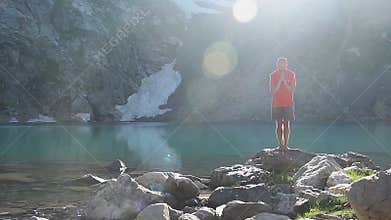 Man bowing on the lake shore, symbolic gesture, Buddhism