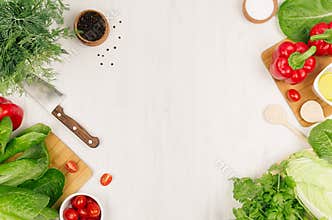 Healthy vegetarian ingredients for spring fresh green salad and kitchenware on white wood board, top view, copy space.