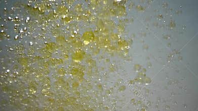 Pouring organic olive oil in water.