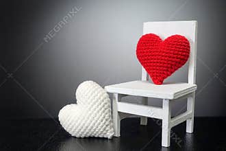 Red heart on white chair and white heart with black background -