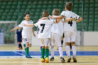 Indoor football soccer match for children. Happy kids together after winning futsal game. Chldren celebrate sport victory. Youth s
