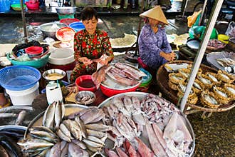 Woman sells fish and seafood on street market in My Tho, Vietnam