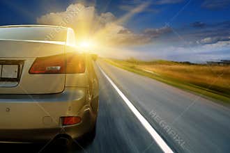 Car driving towards sunshine