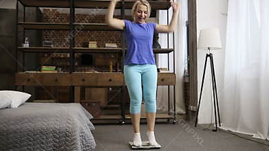 Charming woman with scale celebrating weight loss