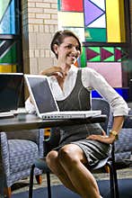 Young woman sitting at table with laptop computers