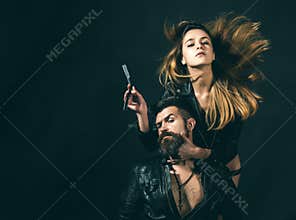 Barber concept. Couple of girl and brutal bearded hipster with mustache, black background. Barber with straight