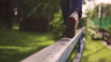 Children`s legs close-up. the child is on the crossbar and balances in the air. the concept of a happy and serene