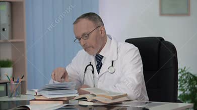 Doctor sitting in front of book heap thinking about topic for his research work