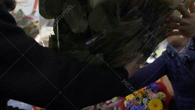 Male worker of flower delivery service received order for huge bouquet of roses