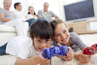 Children playing video games and family on sofa
