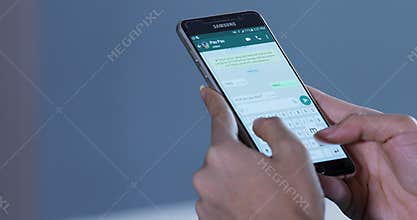 Hands chatting with Whatsapp app on smartphone