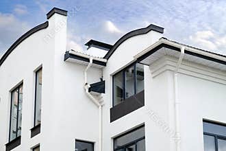 Newly installed construction frame house rain gutter system on the roof top.