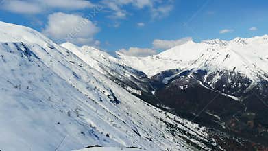 Aerial: flying over hiker on snowy mountain top, ski touring mountaineering snow mountain, panoramic view on the alps, conquering