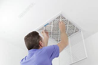 Person Removing Ceiling Air Filter