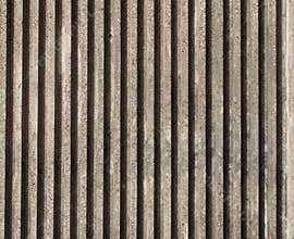 Textured cast concrete wall with vertical lines and stripes