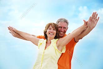 Mature couple with arms outstretched