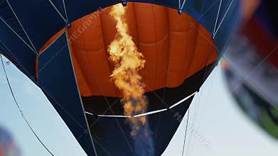 Fire from burner inflates hot air balloon. Flame tongue.