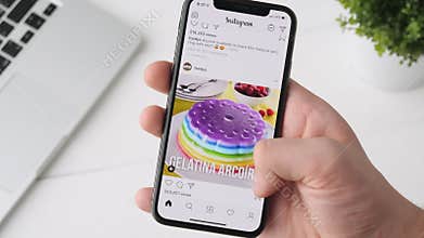 Yekaterinburg, Russia - October 3, 2018: Man using Instagram app on iPhone X smartphone, browsing through the page.