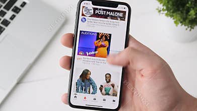 Yekaterinburg, Russia - October 3, 2018: Man using Youtube app on iPhone X smartphone, browsing through the page.