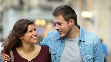 Couple walking and talking towards camera