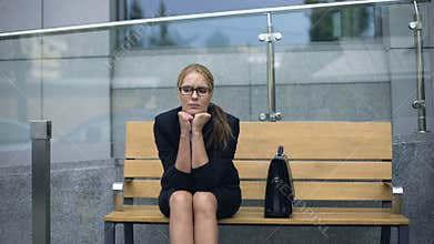Female office employee sitting on bench, worrying bout troubles at work, stress